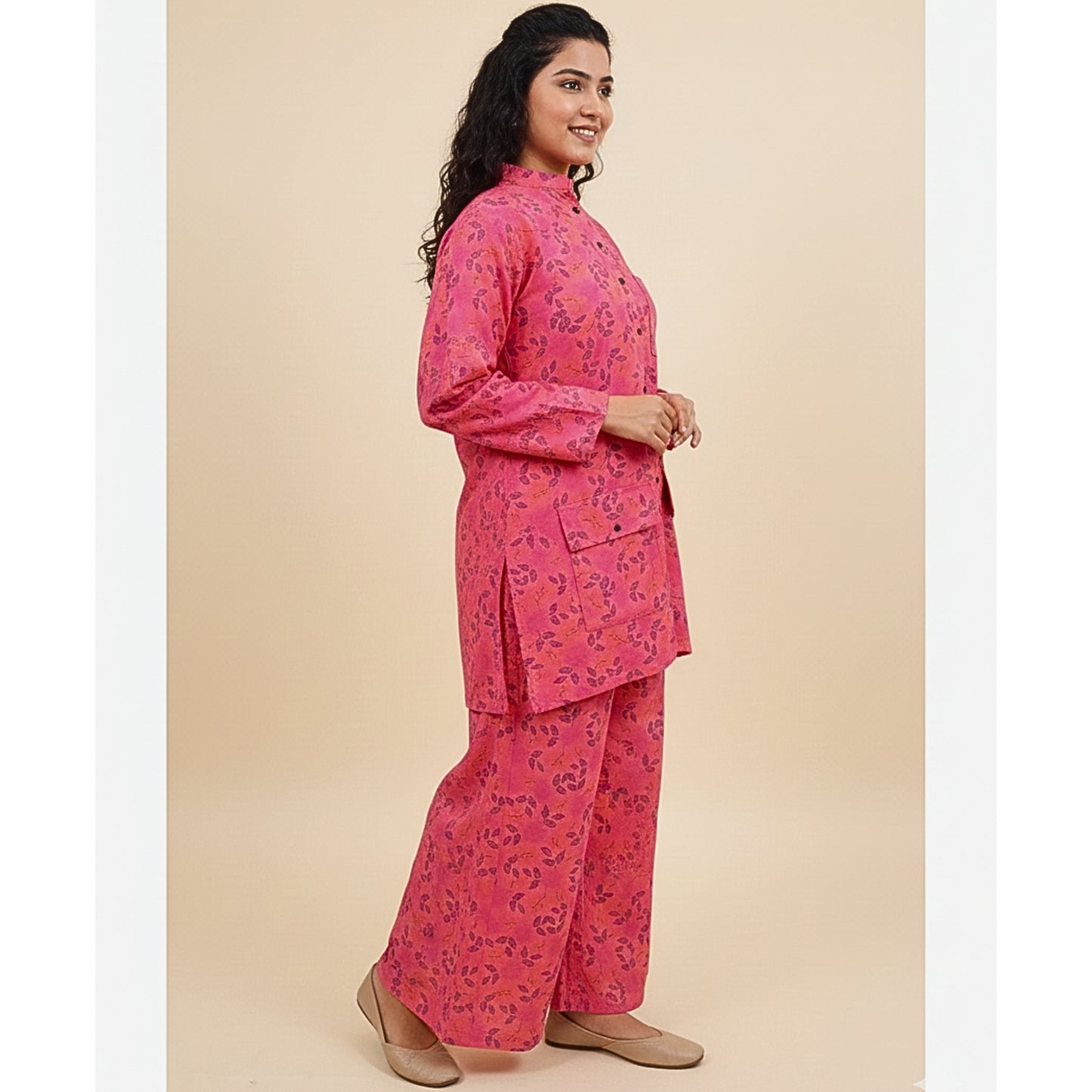 Woman wearing a pink floral outfit on a beige background