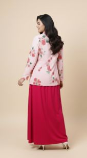 Woman wearing a floral top and red skirt on a beige background