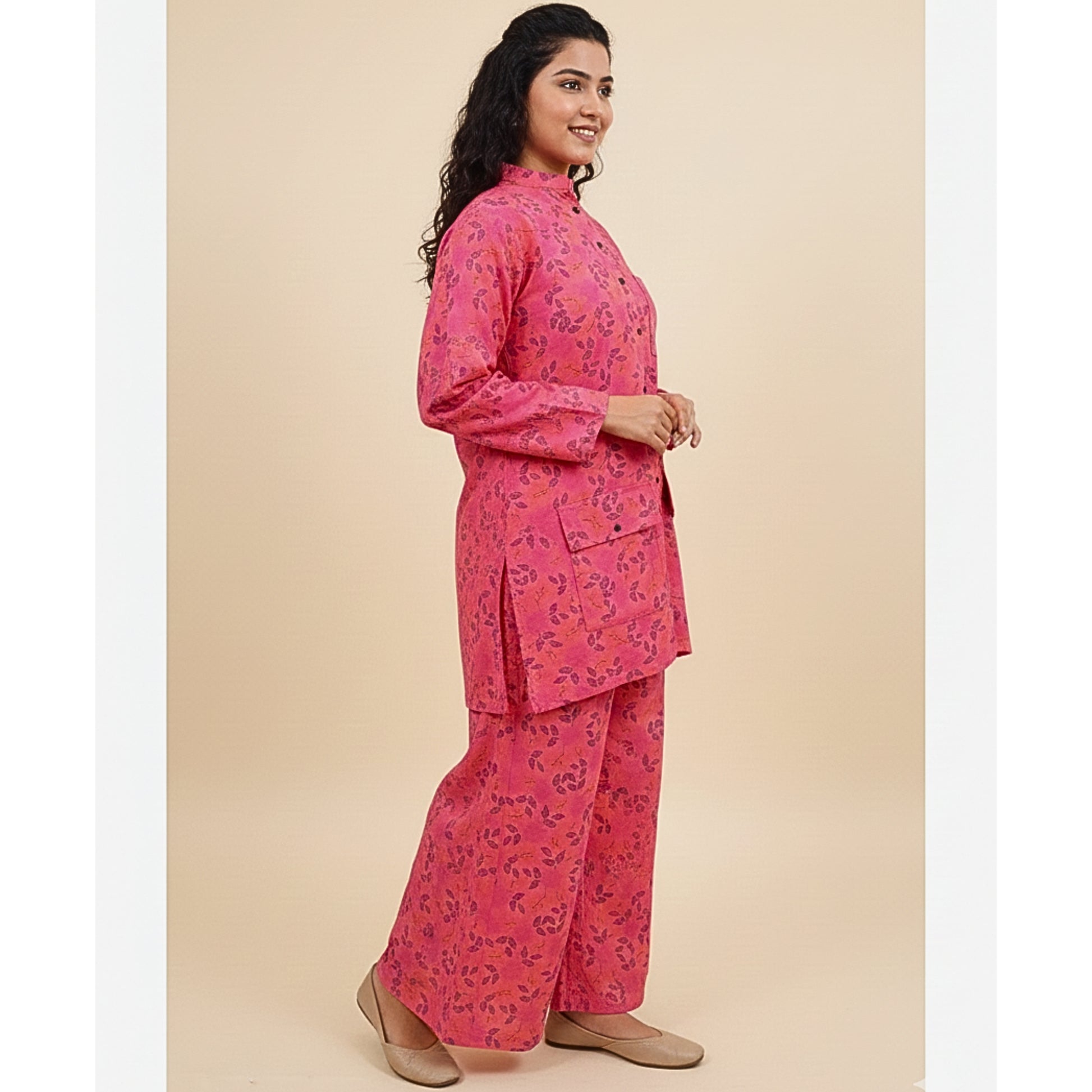 Woman wearing a pink floral outfit on a beige background