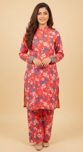 Woman wearing a red floral kurta with matching pants on a beige background