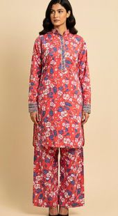 Woman wearing a red floral kurta with matching pants on a beige background