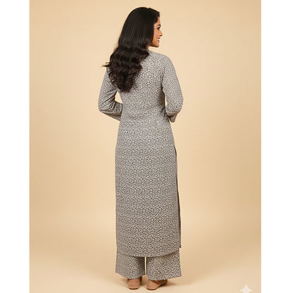 Woman wearing a long, patterned dress on a beige background