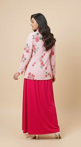 Woman wearing a floral top and pink skirt on a beige background