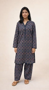Woman wearing a patterned kurta with matching pants on a beige background