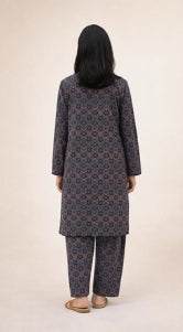 Person wearing a patterned kurta set on a plain background