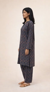 Woman wearing a patterned kurta with pants on a beige background
